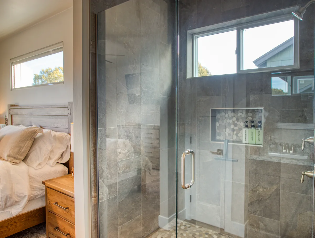 Walk-in glass shower with tile surround in the primary bathroom