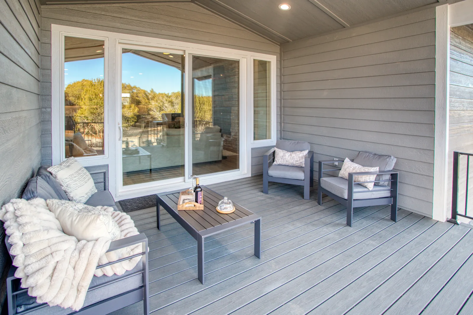 Covered deck seating area with sliding doors to the living room
