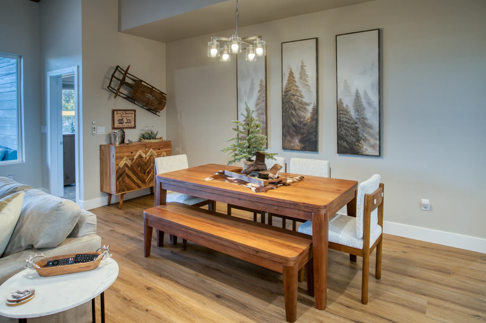 Dining table seating six with bench seating and forest artwork