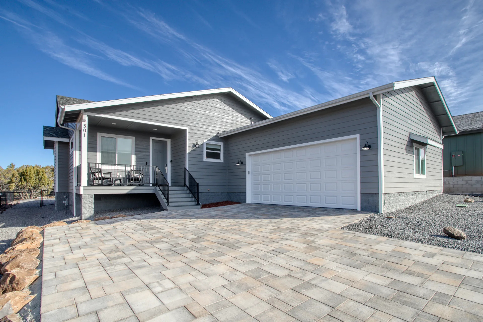 Front exterior of Bluff Retreat vacation home in Show Low, Arizona, with paver driveway and covered entry porch