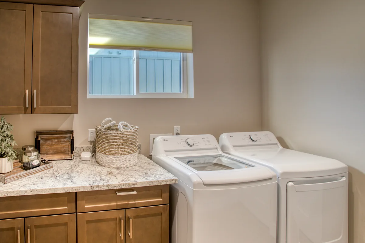 Laundry room with full-size washer and dryer and folding counter